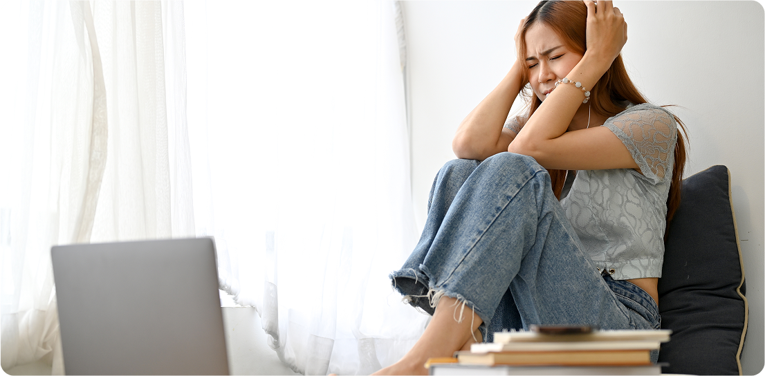 Patient showing signs of distress while sitting with laptop