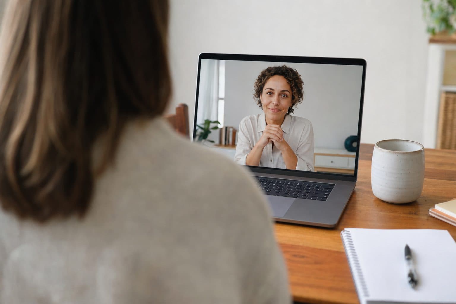 A laptop screen showing a clinician during a video appointment